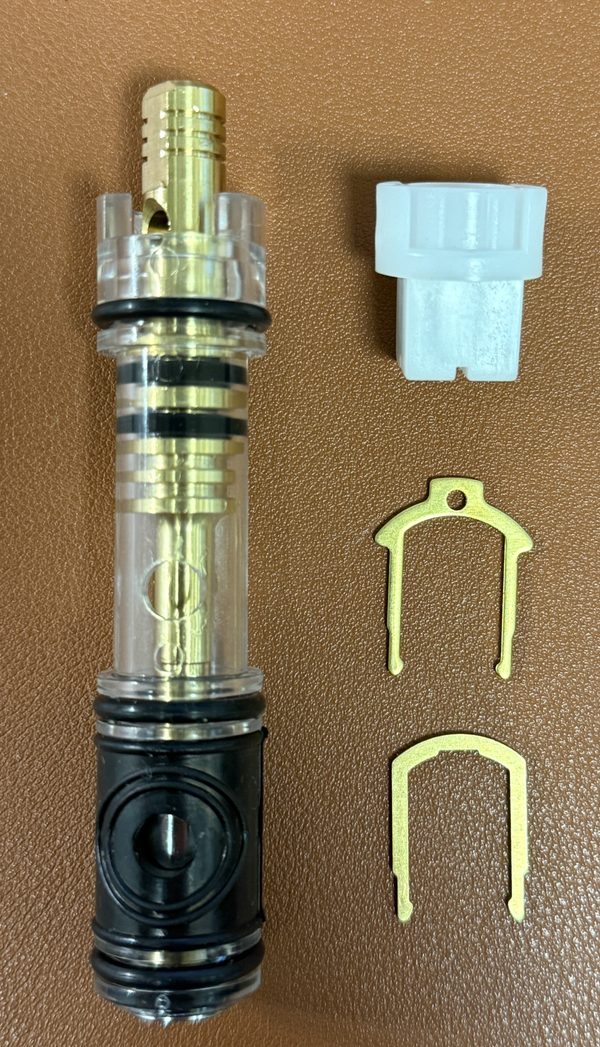 Replacement for Moen 1225 cartridge with a clear plastic shell and brass stem, beside a white twist cap and two retainer clips